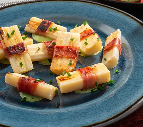 Fotografía de un plato terminado de palmitos guisados acompañados con hierbas frescas