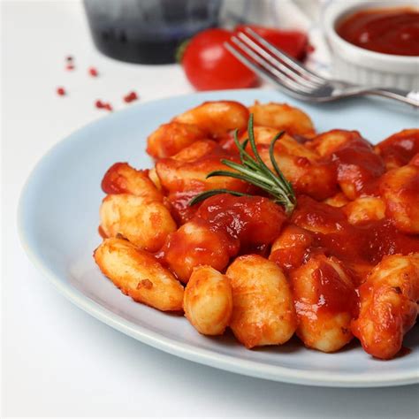 Foto de ñoquis servidos con diferentes salsas (tomate, pesto, queso)