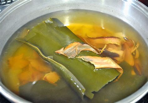 Fotografía de láminas de alga kombu secas junto a un bol de caldo dashi recién preparado.