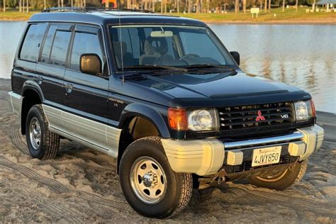 Parrilla frontal de una Mitsubishi Montero de 1999, mostrando detalles del diseño y emblema