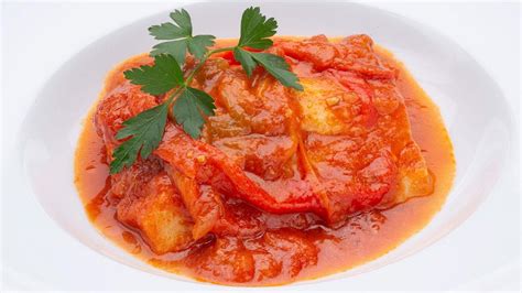 Fotografía de un plato terminado de bacalao a la napolitana con su salsa característica.