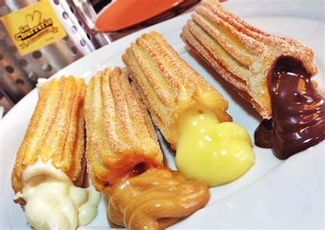 Variedad de churros rellenos y salsas en un plato gourmet