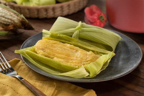 Ilustración de humitas en hojas de maíz cocinadas al vapor