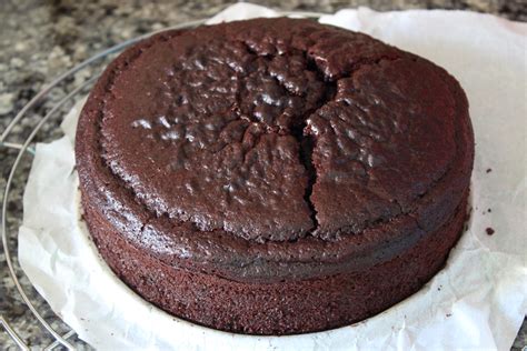 Tarta Devil's Food con capas de bizcocho de chocolate, relleno de crema de frambuesa y cobertura de ganache de chocolate, decorada con frambuesas frescas.