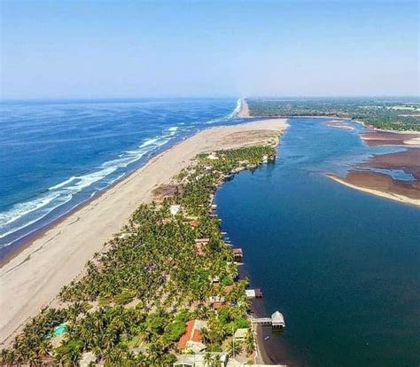 Vista panorámica de la playa de Barra durante el Carnaval de Salvador, con el Farol de Barra al fondo