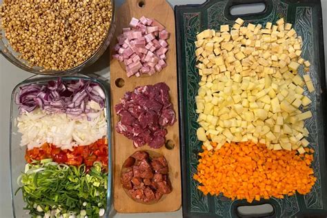 Esquema de los ingredientes principales del guiso: carnes en cubos, vegetales picados y especias sobre una mesa de cocina.