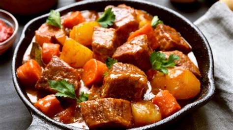 Foto de un guisado cocinándose en una olla abierta, permitiendo la reducción de la salsa