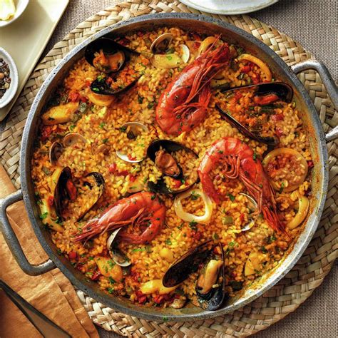 fotografía de una paella terminada con mariscos, servida en su recipiente tradicional