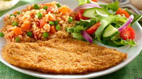 Plato de milanesas de pollo con una porción de arroz y ensalada, decorado con pico de gallo