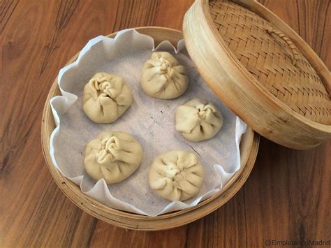 Manos formando un baozi, mostrando la técnica de pliegues