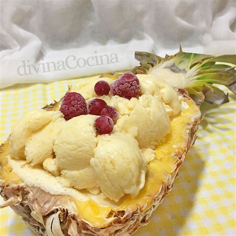 Una piña cortada por la mitad, vaciada y rellena con helado de piña casero