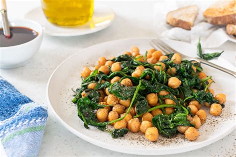 Imagen de un bol con crema de espinacas verde vibrante, decorada con garbanzos y hierbas frescas