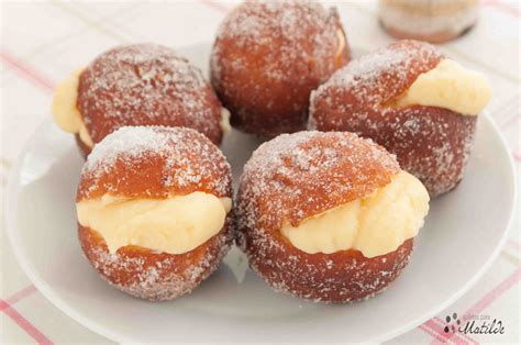 Berlinesas recién hechas rellenas de crema pastelera espolvoreadas con azúcar