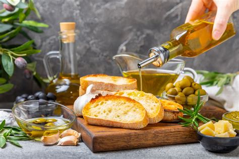 Bodegón con los ingredientes esenciales para un marinado: frasco de aceite, limones, hierbas frescas y vino.