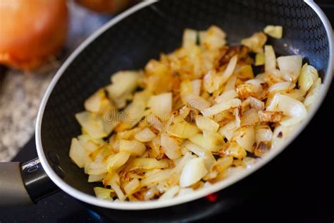 Imagen de cebolla y ajo picados en una sartén con aceite caliente.
