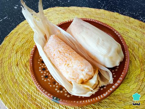 Imagen de un tamal servido en un plato con una guarnición de salsa verde y una taza de atole caliente
