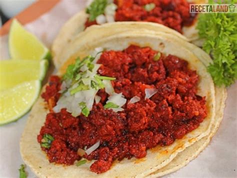 Tacos de longaniza con papas y salsa verde, arroz rojo al fondo