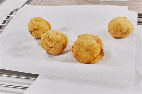 Croquetas recién fritas escurriendo sobre papel absorbente