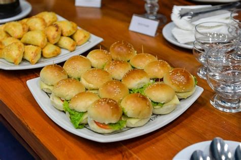 Fotografía gastronómica de mini bocadillos rellenos de ensalada de jamón sobre una bandeja decorativa.