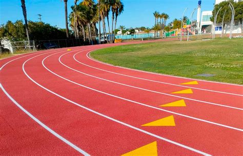 Fotografía de una pista de atletismo moderna de color rojo con líneas blancas