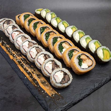 Fotografía profesional de un set variado de 100 piezas de sushi dispuesto en una bandeja grande.