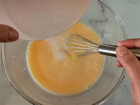 Proceso de batido de yemas con azúcar hasta obtener una mezcla blanquecina.