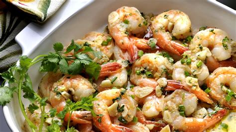 Foto de camarones al ajillo con un toque mexicano, servidos en una sartén o plato de barro
