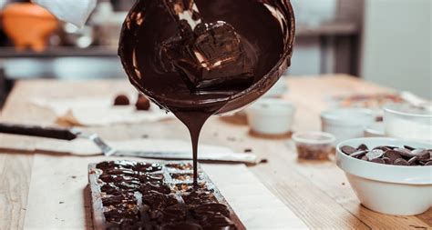 Esquema detallado que muestra la diferencia entre una cobertura de chocolate bien temperada (brillante y lisa) frente a una defectuosa (opaca con manchas de fat bloom)