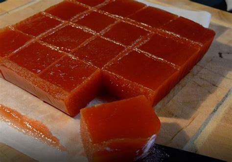 Foto de un trozo de dulce de membrillo sobre una tabla con un trozo de queso