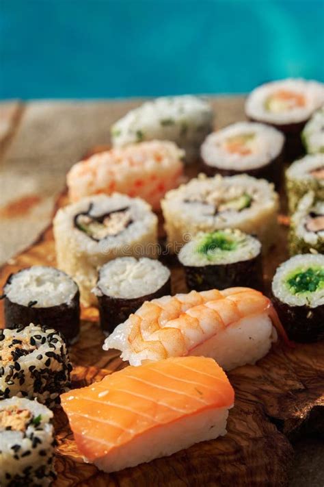 Fotografía gastronómica de un set variado de sushi servido en una tabla de madera tradicional