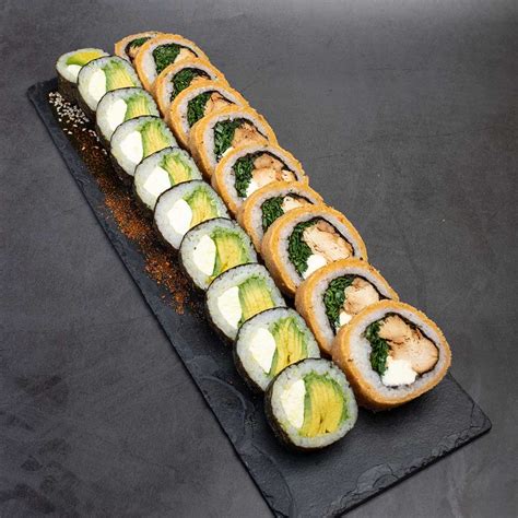 Foto de un plato con 20 piezas de sushi, destacando las piezas panadas de pollo con queso crema y cebollín.