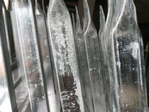 Primer plano de acero galvanizado con óxido blanco, mostrando su textura pulverulenta.