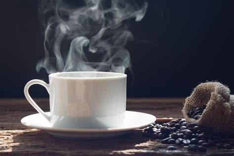 Taza de café humeante con granos de café de fondo, transmitiendo sensación de bienestar.