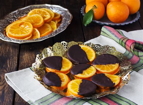 Foto de naranjas confitadas cubiertas de chocolate y una barra de chocolate blanco vegano