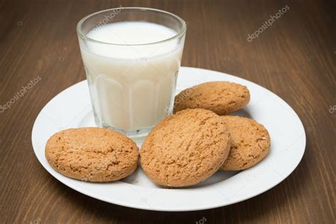 Plato de galletas de avena recién horneadas con un vaso de leche