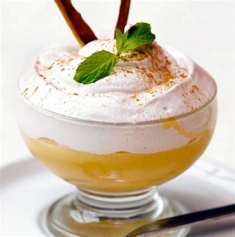 Un primer plano de un vasito de Suspiro Limeño, mostrando la crema de base y el merengue cubierto de canela.