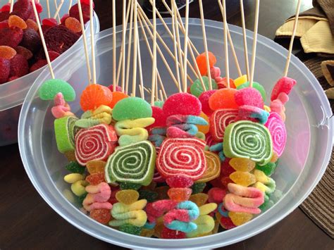 Mesa de dulces con palomitas de maíz, algodón de azúcar y brochetas de frutas en una fiesta de circo