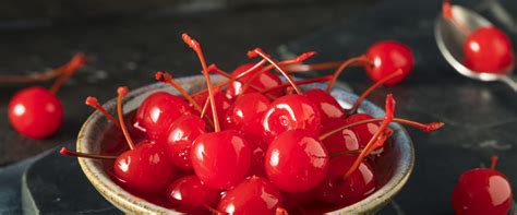 Cerezas al marrasquino envueltas en tocino crujiente en una bandeja, con palillos de dientes