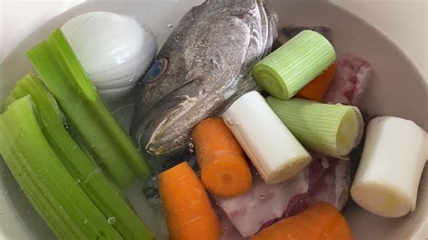 Variedad de ingredientes para caldo, incluyendo huesos de carne, espinas de pescado, y verduras como zanahorias, puerros y cebollas