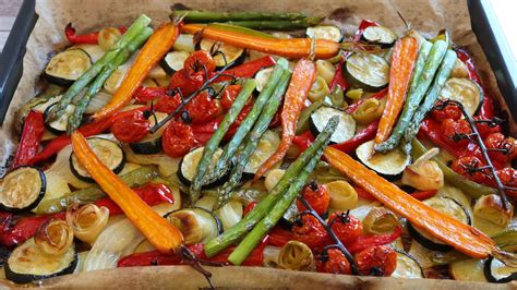 Fotografía del salmón dorado sobre una cama de verduras asadas en una bandeja de horno