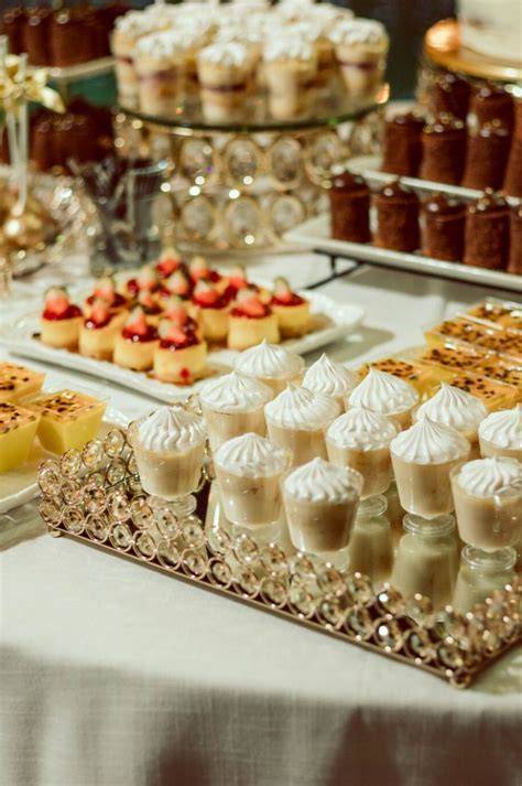 Variedad de postres individuales para mesa de dulces de boda