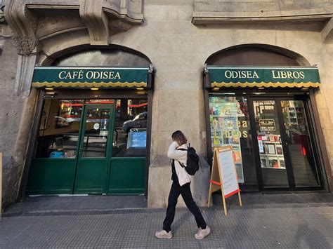 Interior del café Odisea, destacando el mobiliario de estilo antiguo y el piso cuadriculado.