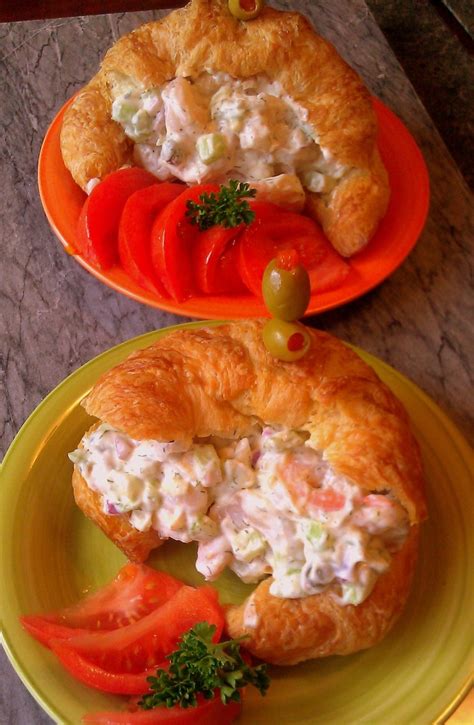 Plato terminado de cuernitos rellenos de ensalada de camarones, decorados con tomate y aceitunas.
