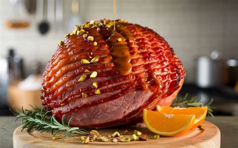 Un jamón entero asado, decorado con rodajas de piña y cerezas, con un glaseado brillante.