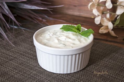 Surtido de ingredientes frescos para salsa de yogur y menta, incluyendo yogur natural, menta fresca, ajo y pepino