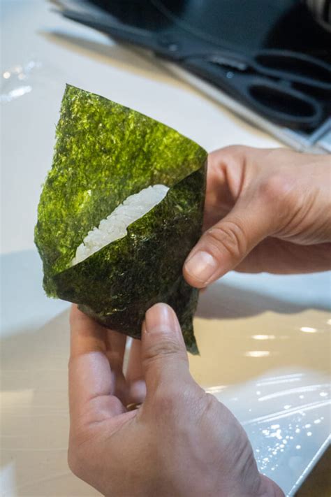 Imagen mostrando cómo envolver un onigiri con una tira de alga nori