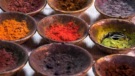 Fotografía de un artista trabajando con tintes naturales de hierbas, mostrando la paleta de colores resultante.