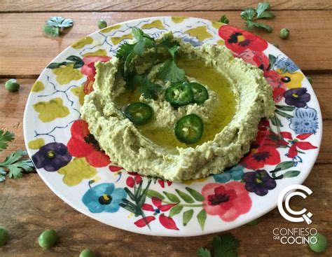 fotografía de un bol con hummus de arvejas decorado con perejil y acompañado de tostadas