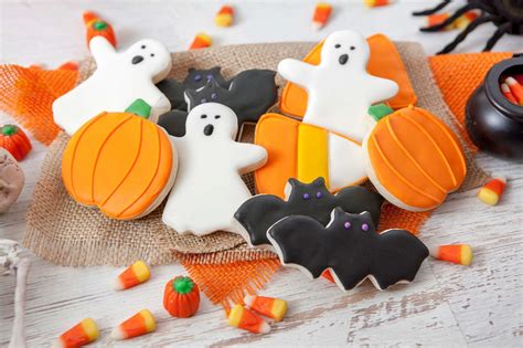 Galletas de Halloween con formas de fantasmas y murciélagos, horneadas y listas para decorar.