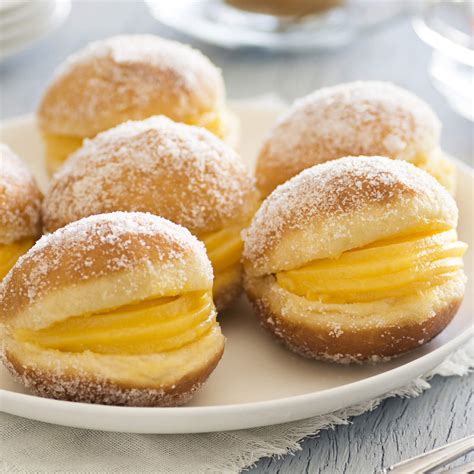 Fotografía detallada de una Bola de Berlim portuguesa con su característico relleno de crema de huevo.